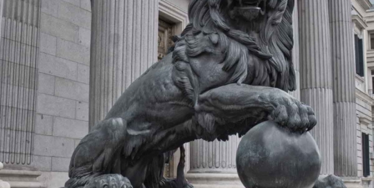 bronze sitting lion statue with ball