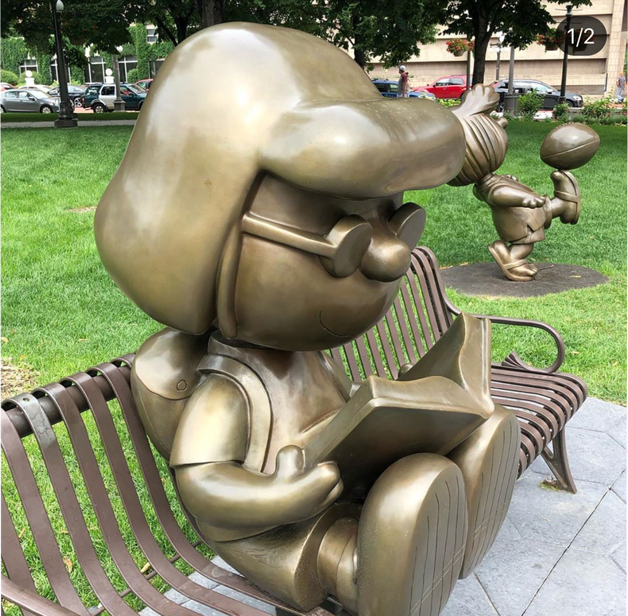 Sculpture of abstract female reading on bench