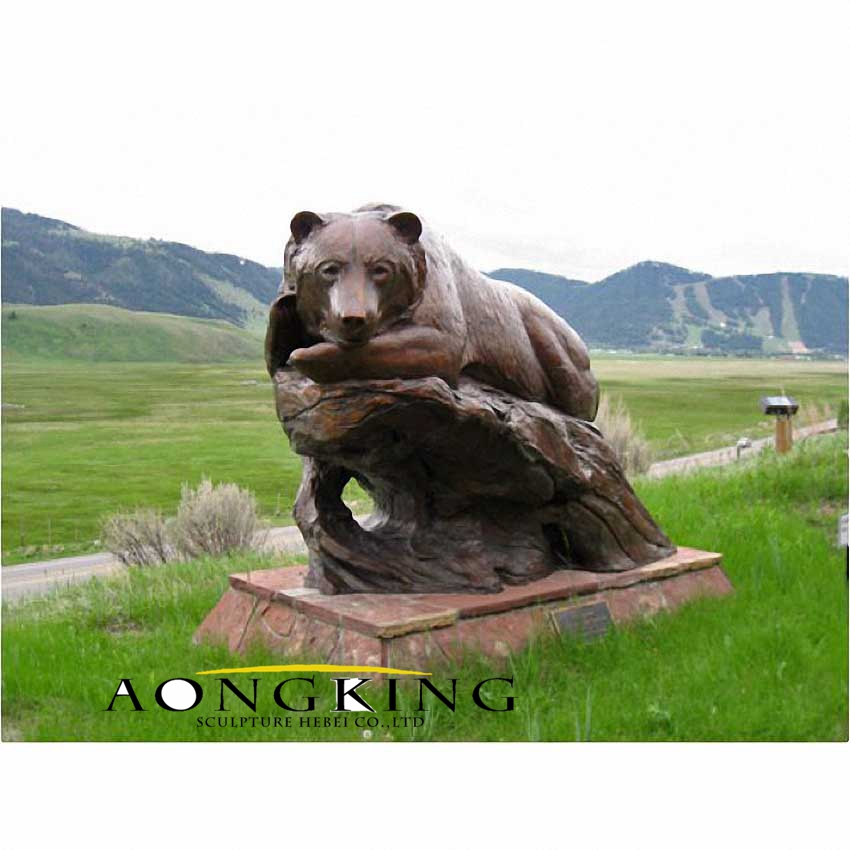 Large bear sleeping on tree bronze statue