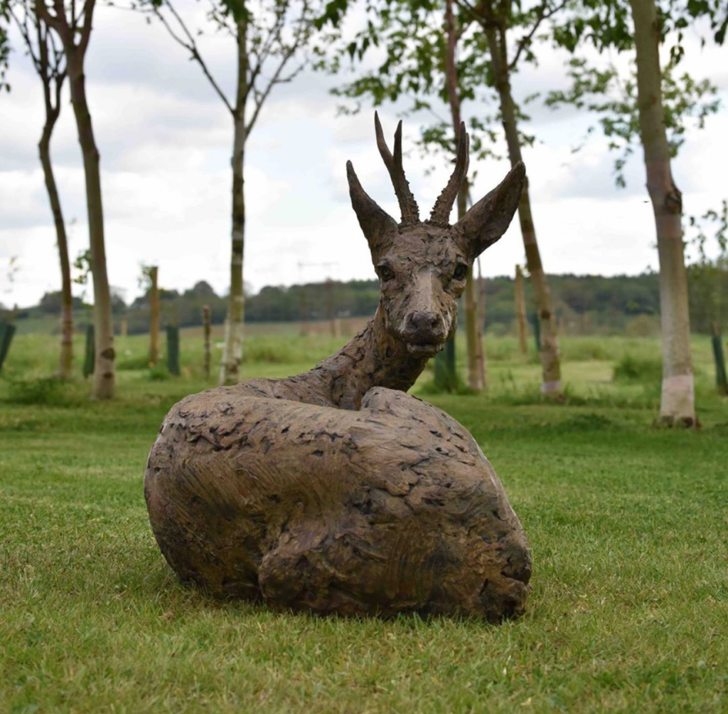 Bronze roe buck lying down sculpture