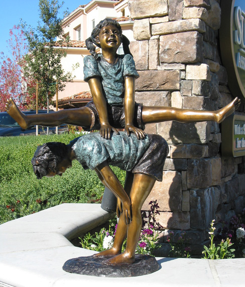 bronze statue children playing leap frog