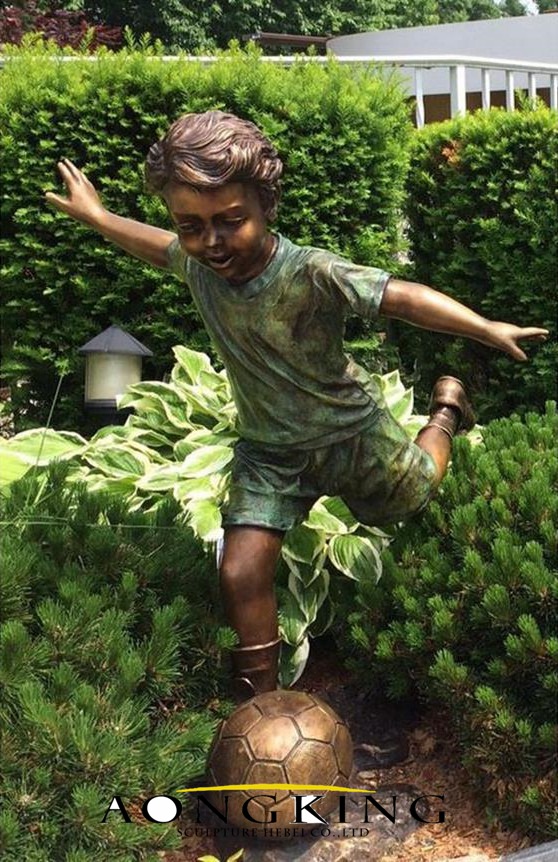 bronze boy playing football sculpture
